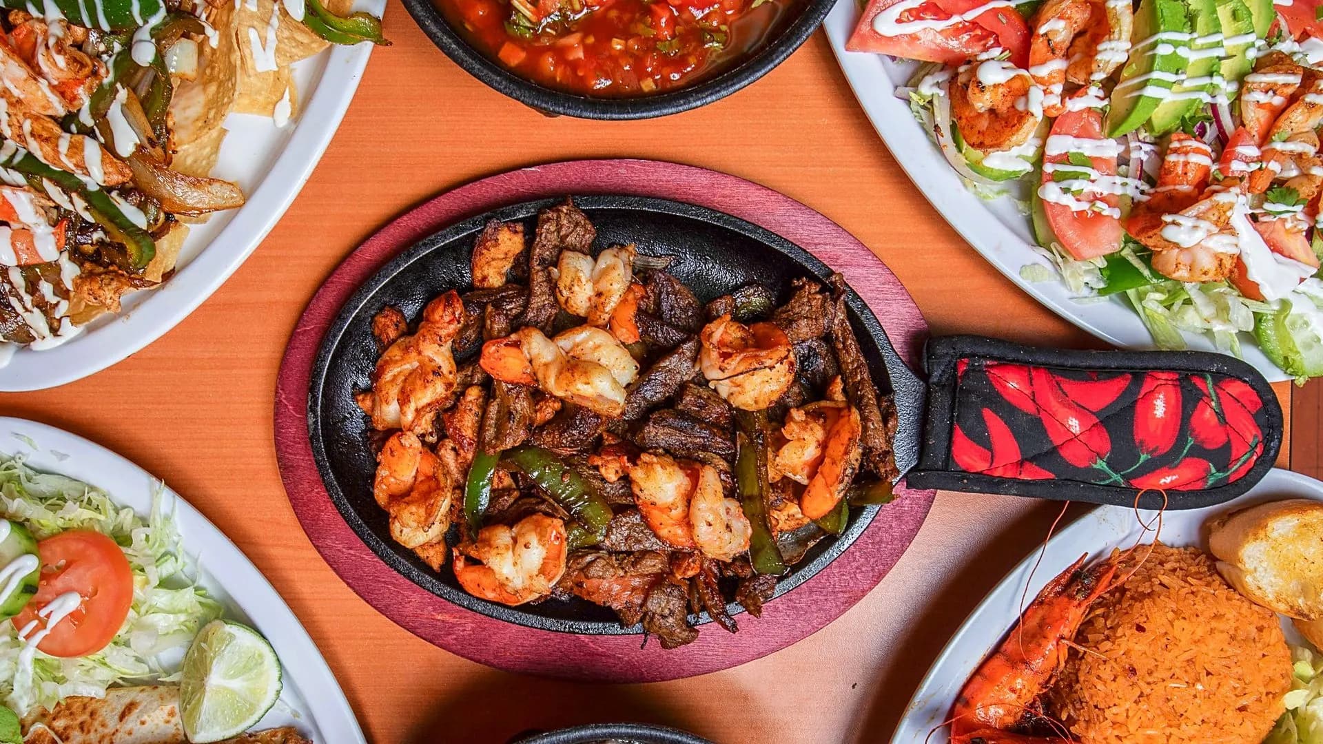 Shrimp and steak fajitas on a sizzling skillet surrounded by shrimp salad, Mexican rice and fresh salsa at Taqueria & Mariscos in Forest Park